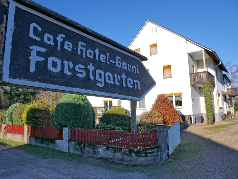 Schild Café Forstgarten mit dem Café im Hintergrund