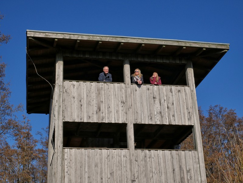 Aussichtsturm mit drei Wanderern, die von oben herab blicken