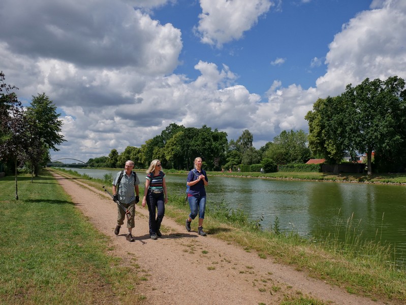 Das Bild zeigt drei Wanderer am Mittellandkanal auf dem Teutoschleifchen Steinbecker Runde.